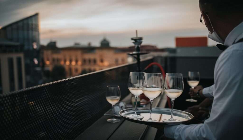 Top 3 Things To Do On Valentine's Day In Mumbai 3 waiter with glasses on roof top restuarant